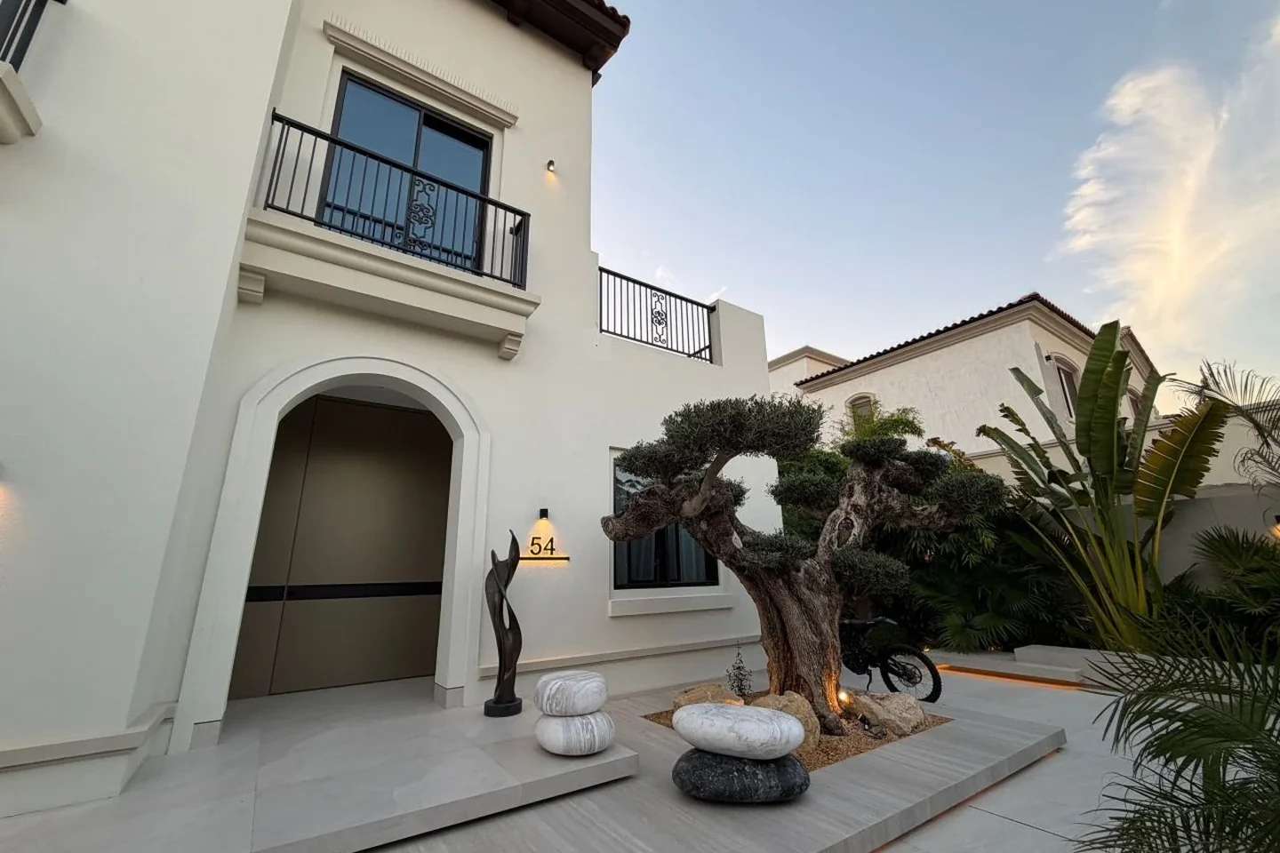 Villa entrance with olive tree and sculptural stone planting